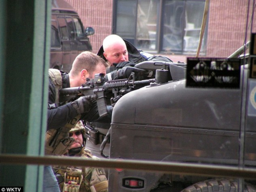 Yes, the EOTech is mounted backwards on the officer's carbine. That's not exactly confidence-inspiring.